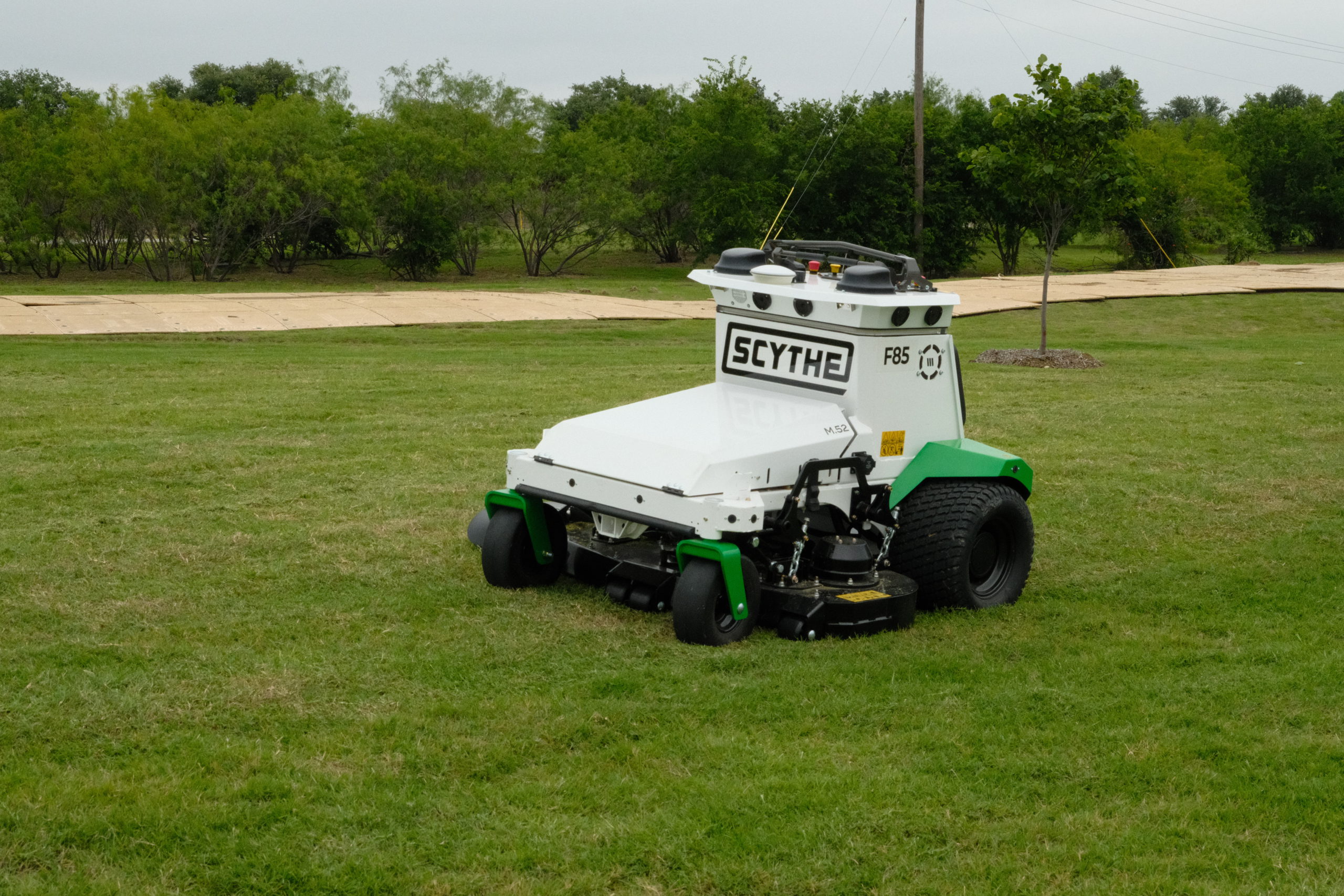 Automatic Scythe robotic mower performing commercial grass mowing at a SITE Landscape Development property.